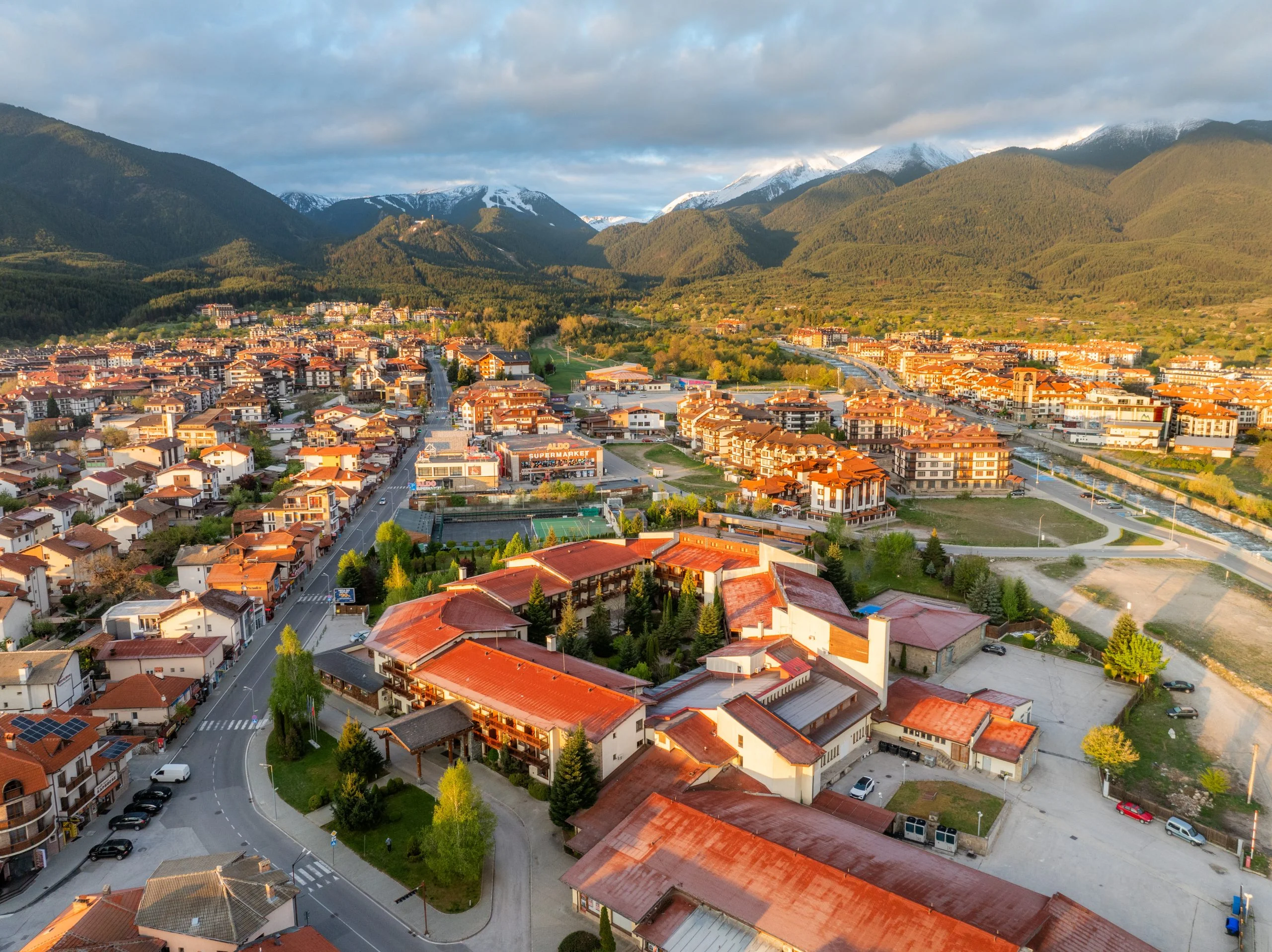 Neubau-Apartmentanlage mit Pool im Abendlicht vor dem Pirin-Gebirge